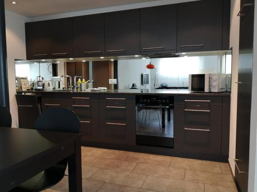 una cocina con armarios de color marrón oscuro y una mesa en Apartment Gornerhaus, en Grindelwald