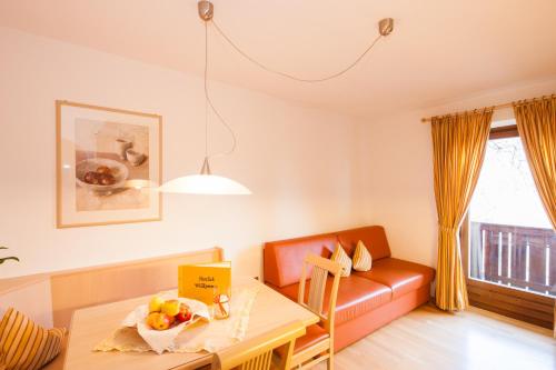 a living room with a table and a couch at Appartements Kirchtalhof in Lana
