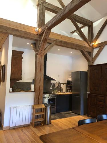 Il comprend une cuisine dotée de poutres apparentes et d'un réfrigérateur noir. dans l'établissement La Chavache, à Montriond
