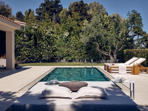 a pool with a table and pillows in front of a house at Cielo villas - An Authentic Mediterranean Living in Zakynthos Town