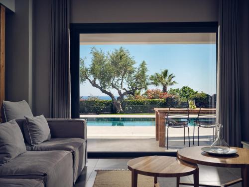 a living room with a view of a swimming pool at Cielo villas - An Authentic Mediterranean Living in Zakynthos Town