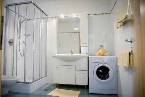 a bathroom with a washing machine and a sink at Appartements Kirchtalhof in Lana