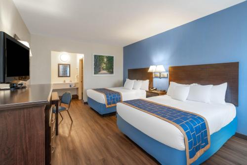 ein Hotelzimmer mit 2 Betten und einem Schreibtisch in der Unterkunft Days Inn by Wyndham Grants in Grants