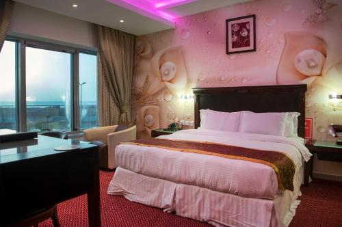 a bedroom with a large bed with a pink wall at Jazan Inn Hotel in Jazan