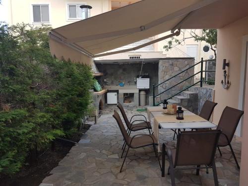 a patio with a table and chairs and a kitchen at cozy apartment nafpaktos in Nafpaktos