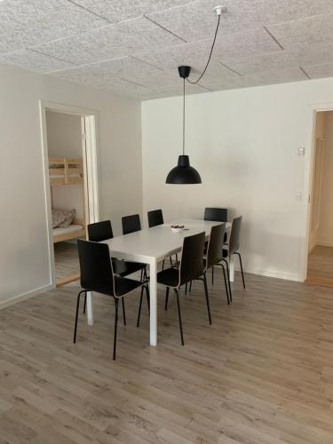a dining room with a white table and chairs at Lokk-Inn Apartments in Norðdepil