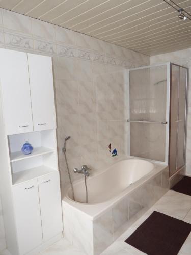 a white bath tub in a room with at Haus Bergblick in Lindberg