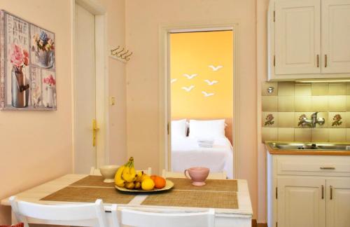 a kitchen with a table with a bowl of fruit on it at Andros Apartment - Lasia in Andros