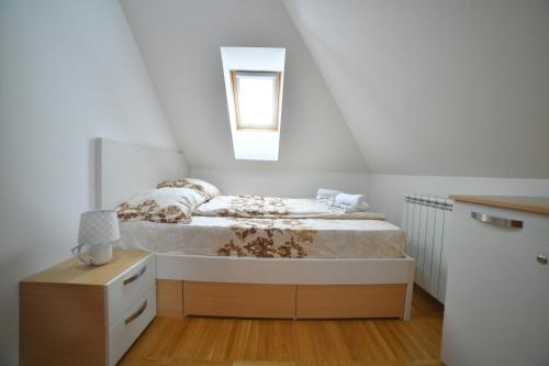 una piccola camera con letto e comodino di Apartman NENA LA VIDA a Zlatibor