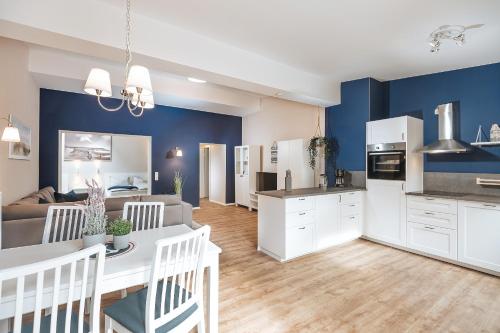 a kitchen and living room with blue walls at Apartments Am Erdbeerhof in Rövershagen