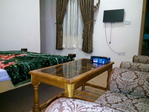 a living room with a coffee table and a bed at Heaven Lodge Gilgit in Gilgit