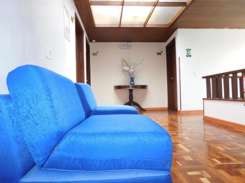 a blue couch in a living room with a table at Hotel Casa Navi in Bogotá