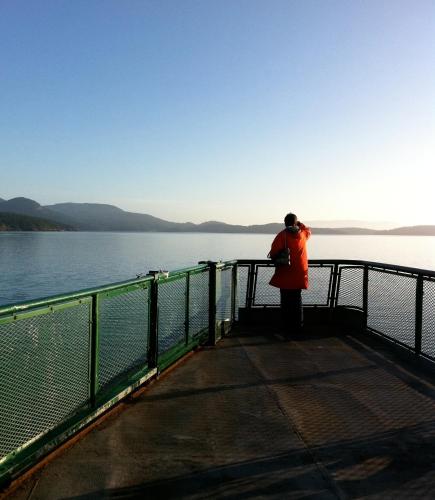 a person standing on the end of a pier looking at the water at Island Inn at 123 West in Friday Harbor