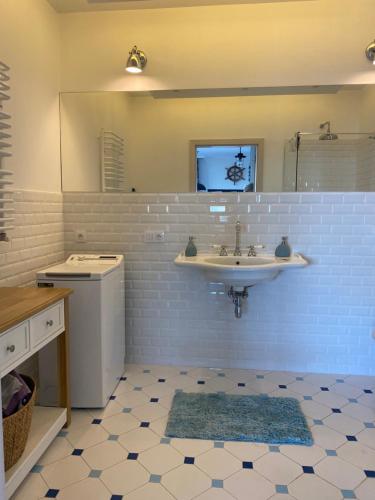 a bathroom with a sink and a mirror at Apartament Błękitny przy Latarni in Darłowo