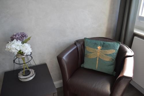 a brown chair with a pillow on it next to a table at Haus Neunaber in Norderney