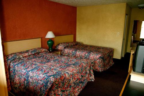 Cette chambre comprend deux lits et une télévision. dans l'établissement Holiday Lodge - Salem,OR, à Salem