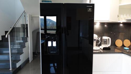 a kitchen with a black refrigerator and a staircase at DOMINO-APARTAMENTY Blue in Krościenko