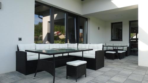 a patio with white chairs and a glass table at DOMINO-APARTAMENTY Red in Krościenko
