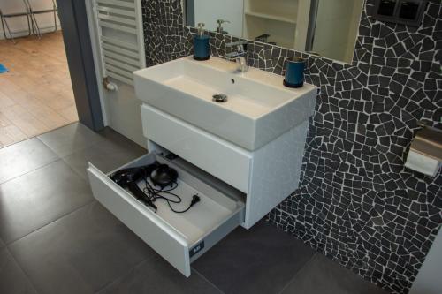 a bathroom with a white sink and a mirror at DOMINO-APARTAMENTY Red in Krościenko