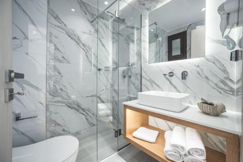 a bathroom with a shower and a toilet and a sink at Alektor Luxury Apartments in Zakynthos