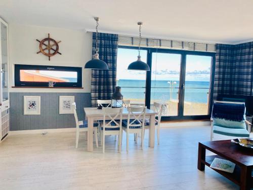 a dining room with a table and a view of the ocean at Apartament Błękitny przy Latarni in Darłowo