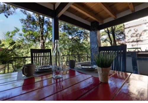 a wooden table with plates of food on a porch at Deluxe Cabin Located in the Woods with Private Jacuzzi - Valle 2 in Valle de Bravo