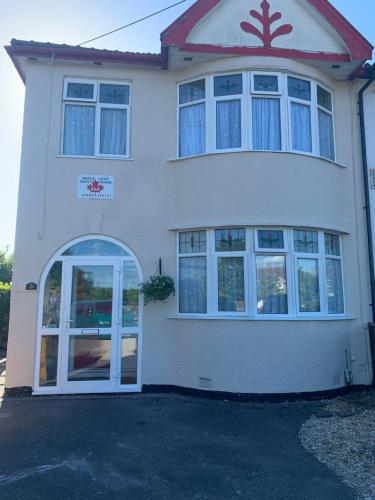 a white house with a white door and windows at Maple Leaf Guest House in Bristol