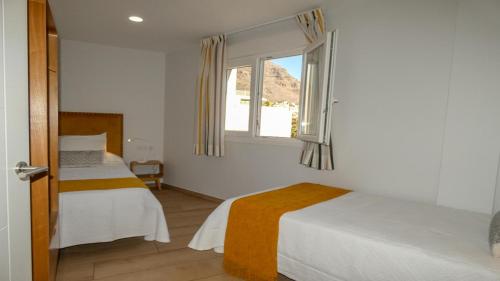 - une chambre avec 2 lits et une fenêtre dans l'établissement El Guanche B, à Valle Gran Rey
