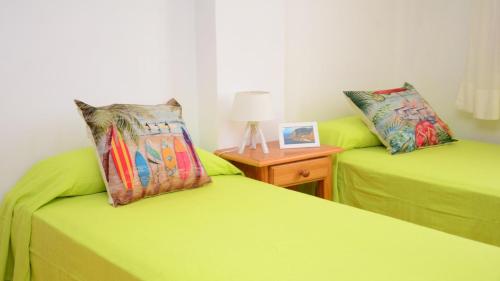 dwa limonkowe łóżka w pokoju ze stołem w obiekcie La Casa Grande w mieście Valle Gran Rey