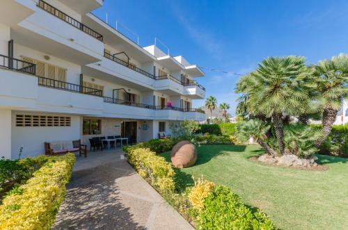 an exterior view of a building with a yard at Venecia Apartments in Port d'Alcudia