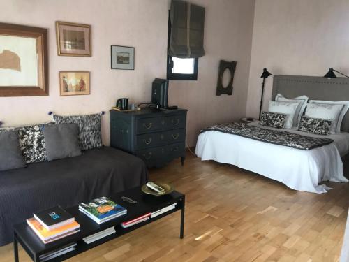 a living room with a bed and a couch at Les Chambres de l'Abbaye in Marseille