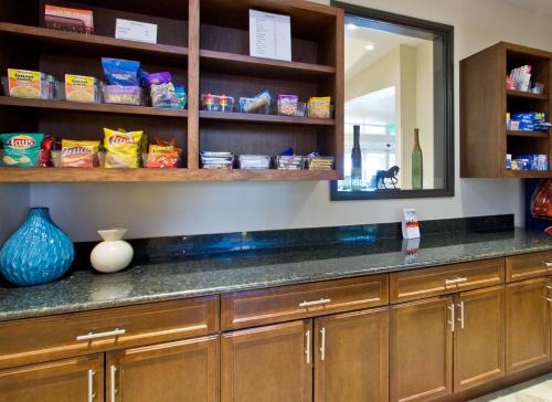 a kitchen with a counter and a mirror at Holiday Inn Express and Suites Denver East Peoria Street, an IHG Hotel in Denver