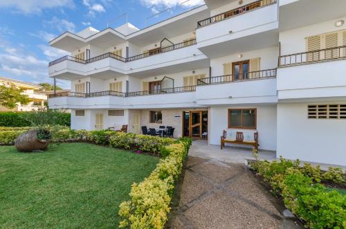 an exterior view of a building with a yard at Venecia Apartments in Port d'Alcudia