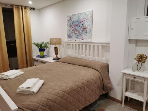 a bedroom with a bed with two towels on it at Isabel do Couto - casa de charme in Castro Daire