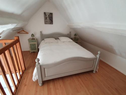 ein Schlafzimmer mit einem weißen Bett im Dachgeschoss in der Unterkunft Welcome-to-Burgundy in Nuits-Saint-Georges