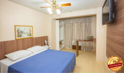 1 dormitorio con 1 cama azul y ventilador de techo en Letto Hotel Porto Alegre en Porto Alegre