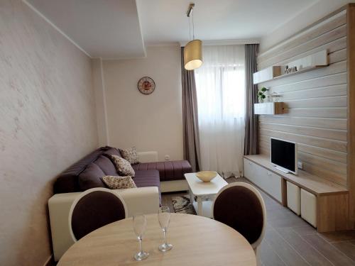 sala de estar con 2 mesas y sofá en Sunset Zlatibor Hills, en Zlatibor