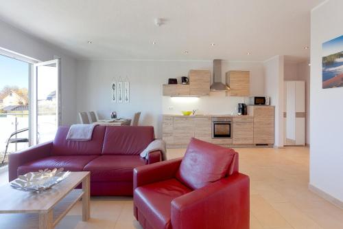 un soggiorno con un divano rosso e un tavolo di Ferienwohnung Bug a Zinnowitz