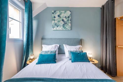 a blue bedroom with a bed with two blue pillows at The Fabulous - Fairytale Factory in Bussy-Saint-Georges