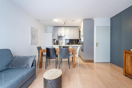 un salon avec un canapé, une table et des chaises dans l'établissement The Fabulous - Apartment 6 Pers 10min Disney, à Bussy-Saint-Georges