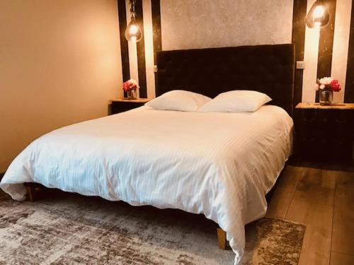 sypialnia z dużym łóżkiem z białą pościelą i poduszkami w obiekcie Les Chambres d'Hotes chez Alisa et Daniel w mieście Sarlat-la-Canéda