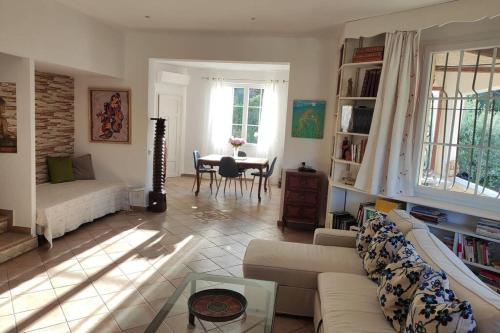 ein Wohnzimmer mit einem Sofa und einem Tisch in der Unterkunft Suite Tropézienne in Saint-Tropez