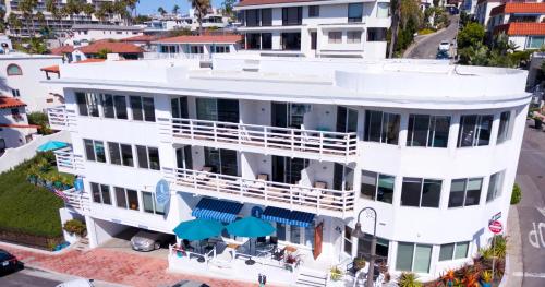 an aerial view of a white building with blue umbrellas at Sea Horse Resort in San Clemente