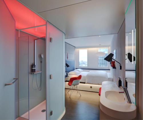 a bathroom with a shower and a bedroom with a bed at citizenM Paris Gare de Lyon in Paris