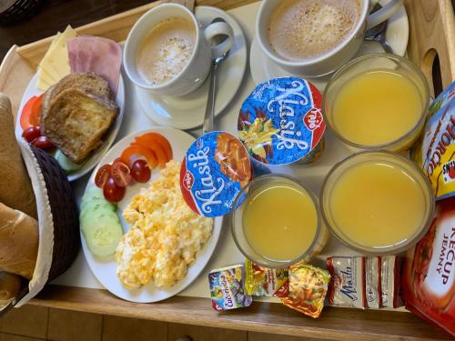 a tray of breakfast food with eggs and cups of coffee at Vila Martina in Poprad