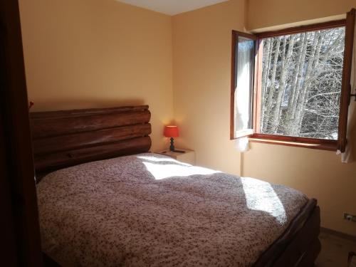 a bedroom with a bed and a window at Casetta all'Abetone Jacopo e Sabrina in Abetone