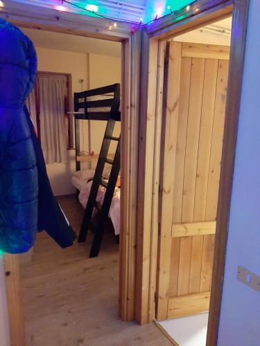 a room with a wooden door and a ladder at Casetta all'Abetone Jacopo e Sabrina in Abetone