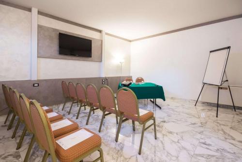 a child sitting at a table in a room with chairs at Best Western Modena District in Campogalliano