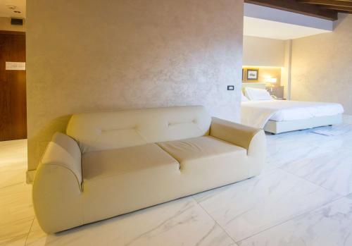 a living room with a couch and a bed at Best Western Modena District in Campogalliano
