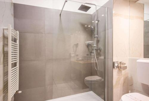 a bathroom with a glass shower with a toilet at Best Western Modena District in Campogalliano